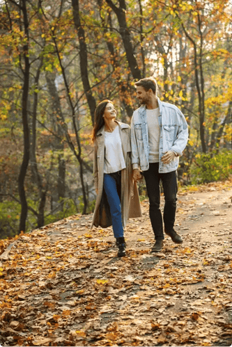 Man en vrouw lopen hand in hand in het bos. Ze kijken naar elkaar. Man en vrouw lopen hand in hand in het bos. Ze kijken naar elkaar.