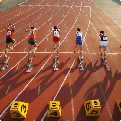 Atletiekbaan met 5 atleten die starten vanuit hun startblokken