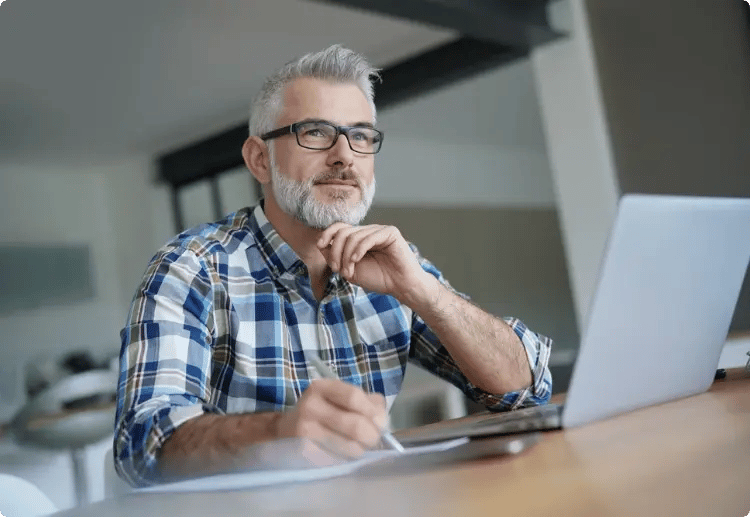 Man achter laptop kijkend naar buiten denkend wat een etf is