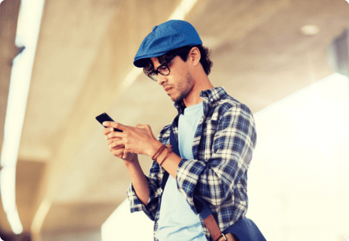 Jongeman kijkend op telefoon naar wat beleggen eigenlijk is