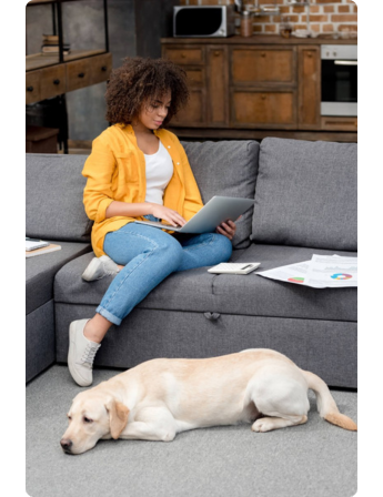 Vrouw achter laptop met hond naar haar zoekend naar de voordelen van obligaties