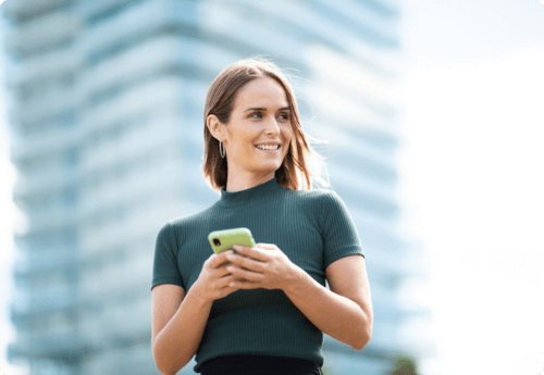 Vrouw met telefoon kijkend opzij bezig met periodiek beleggen