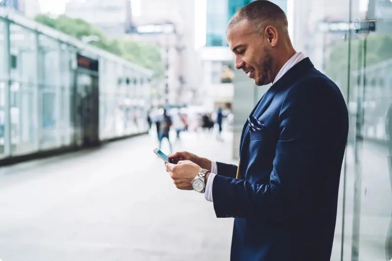 Man met telefoon kijkend of beleggen interessant is voor hem